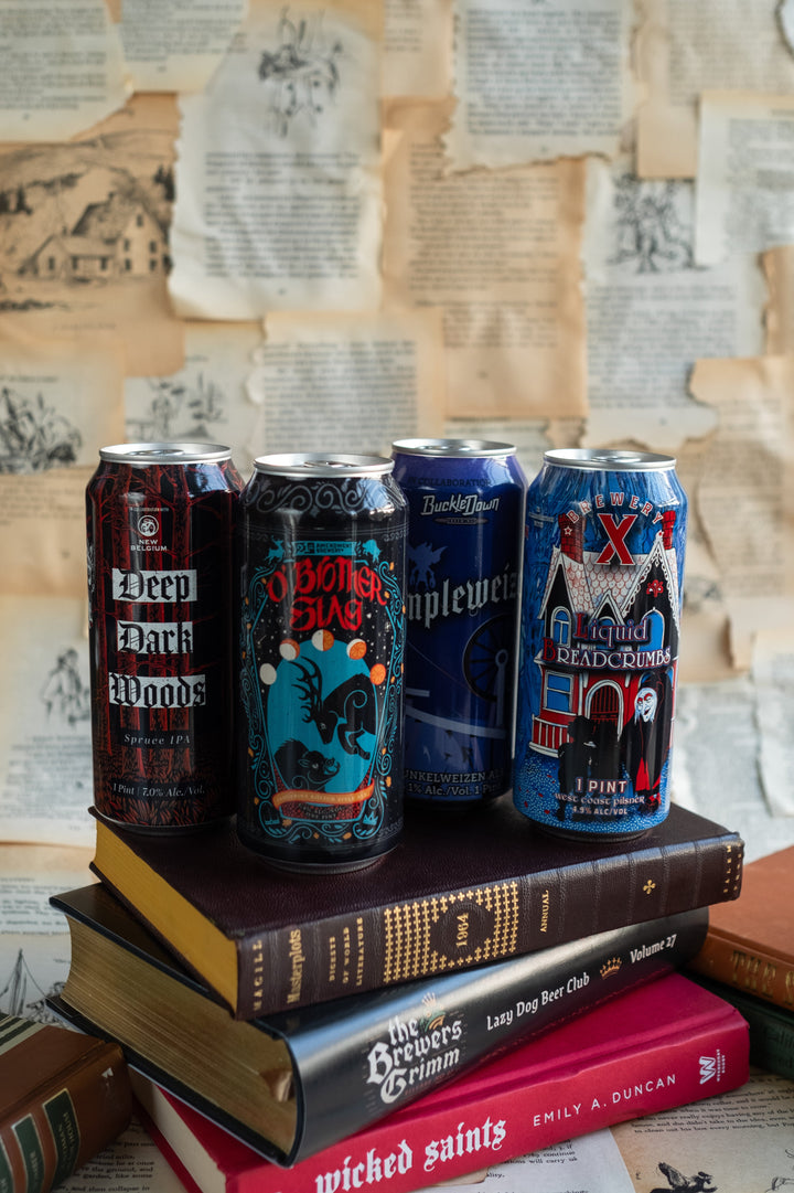 Four beer cans on a stack of books with a textured paper wall background