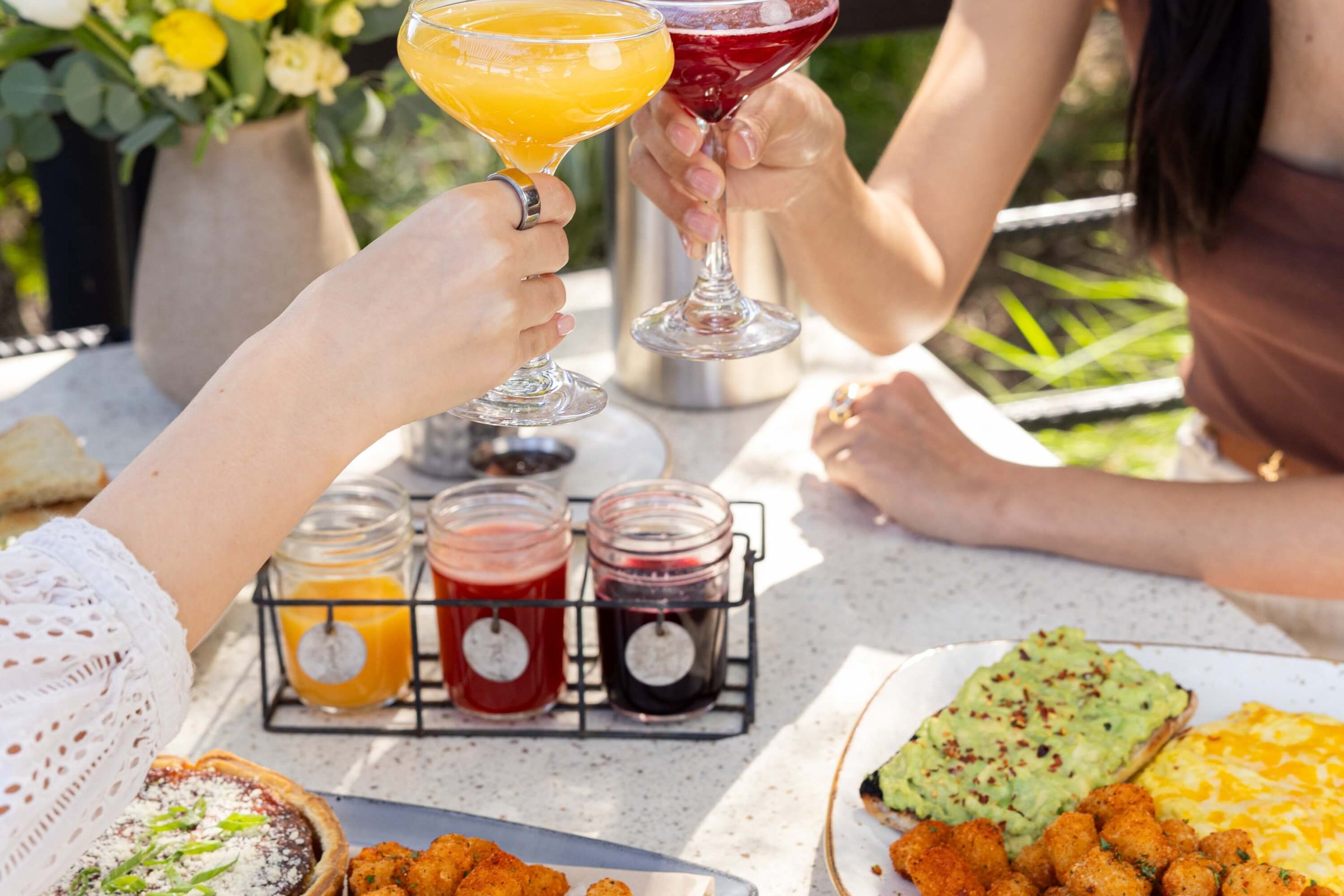 DIY mimosa flight with various brunch dishes on a table