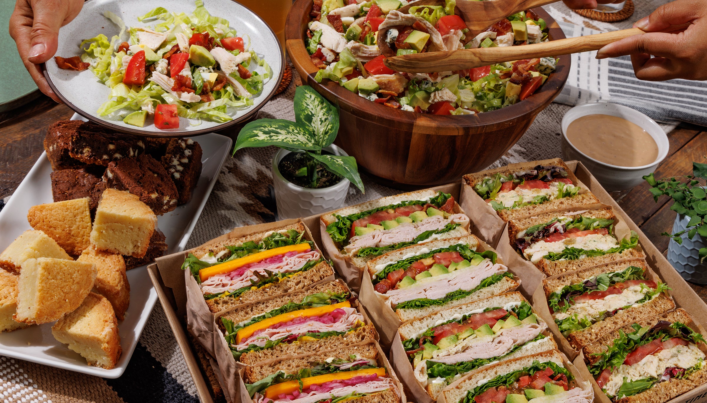 Assorted food including sandwiches, salad, and bread on a table.